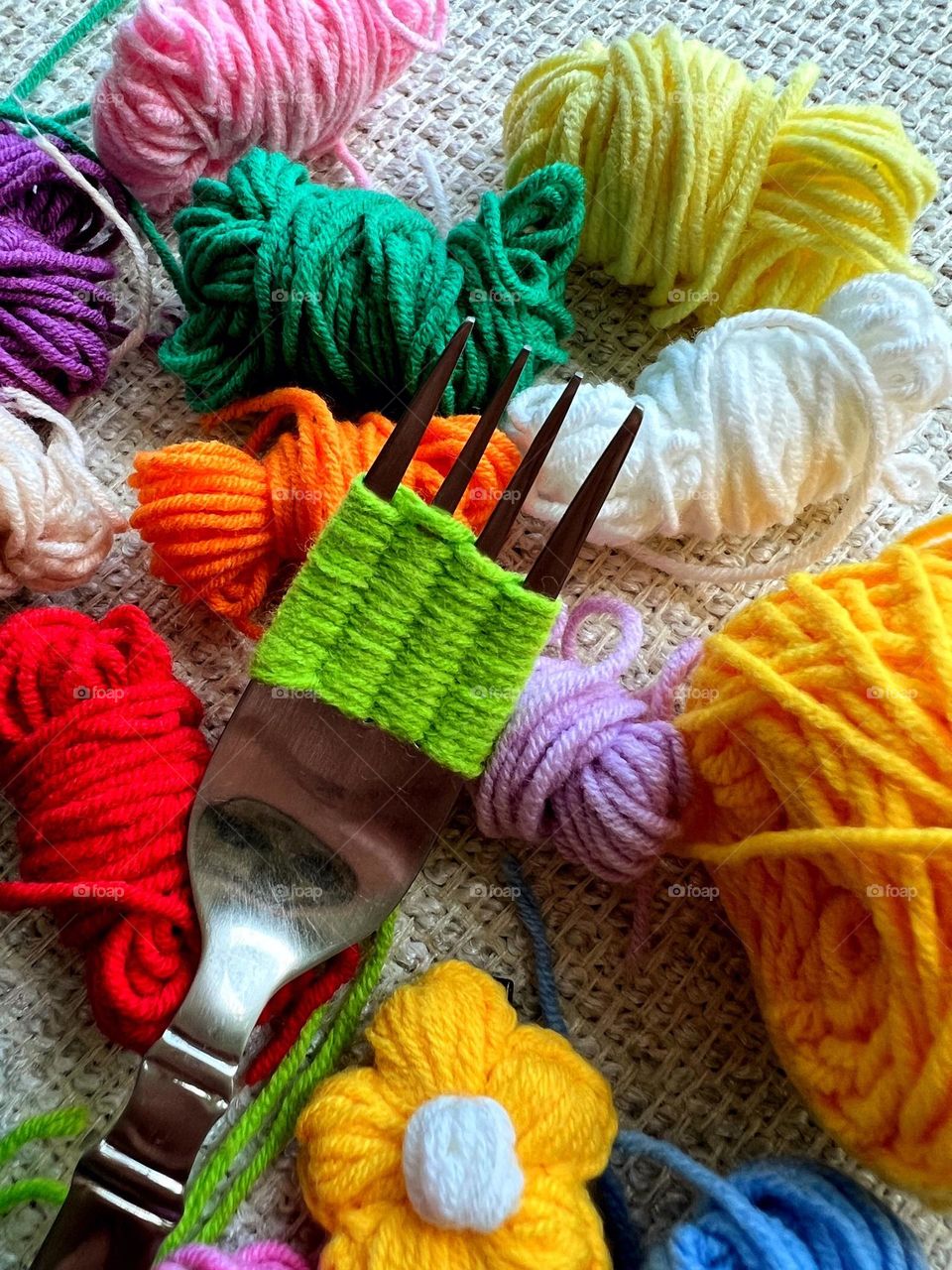 A fork with colorful woolen yarn.