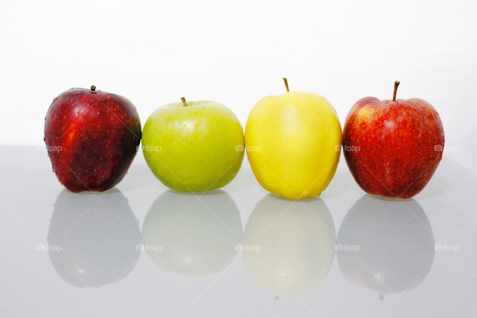 Four types of apples at isolated background with reflection 