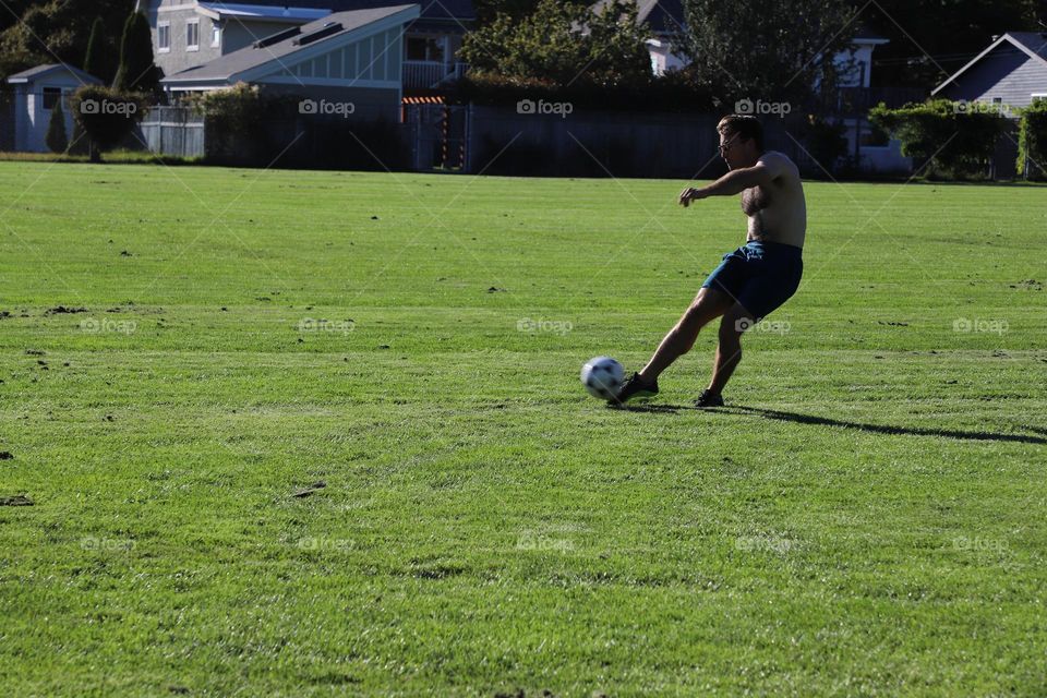 Young man practicing soccer on a field