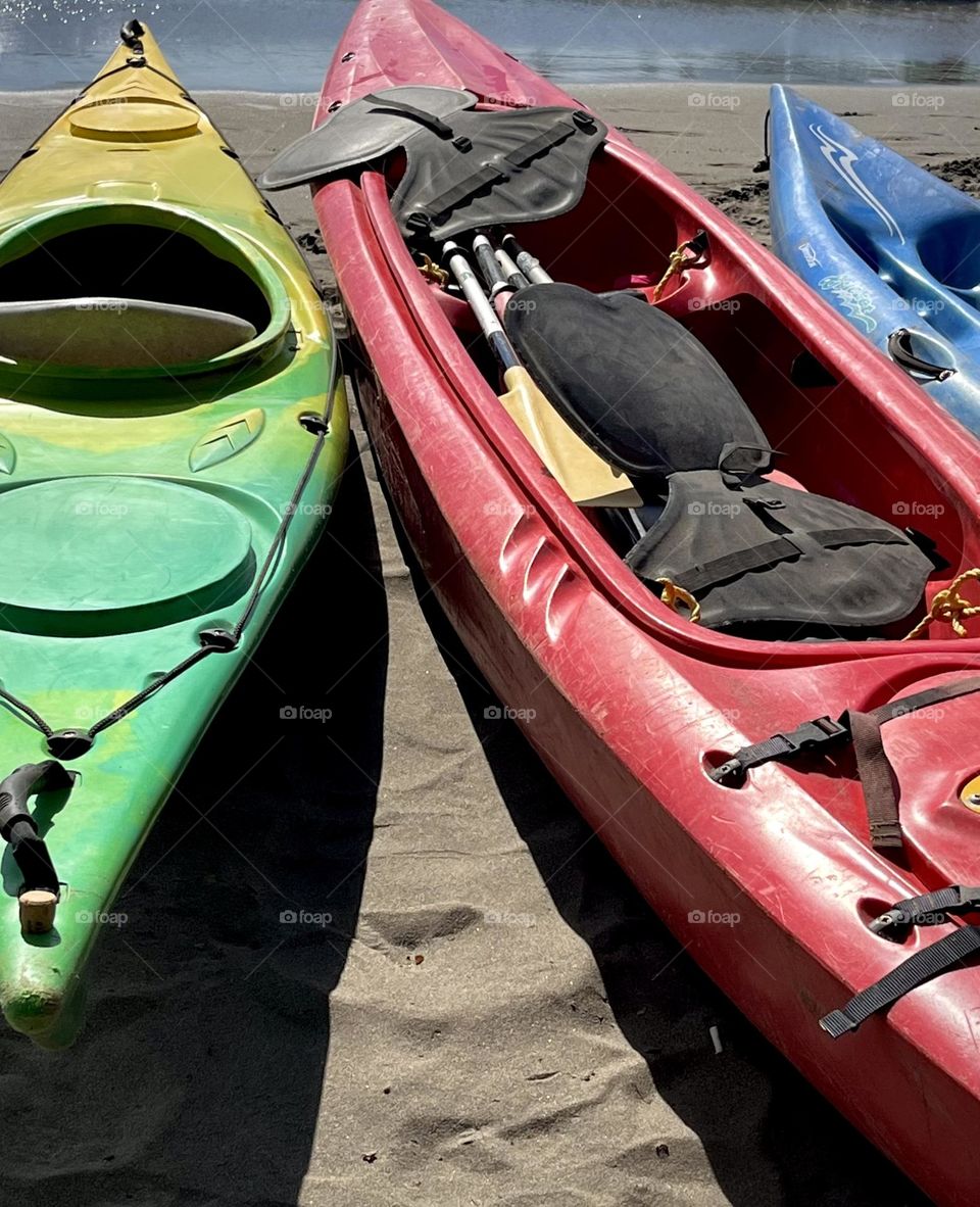 Close-up of kayaks placed on the sand of the beach