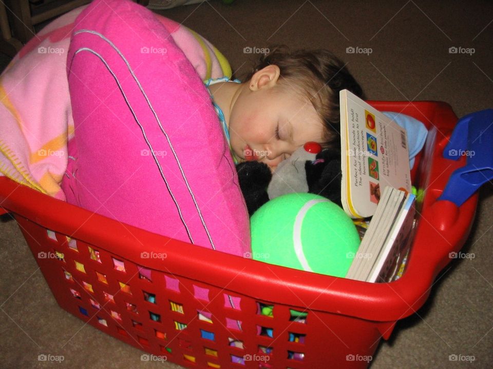 Child sleeping on a toy box