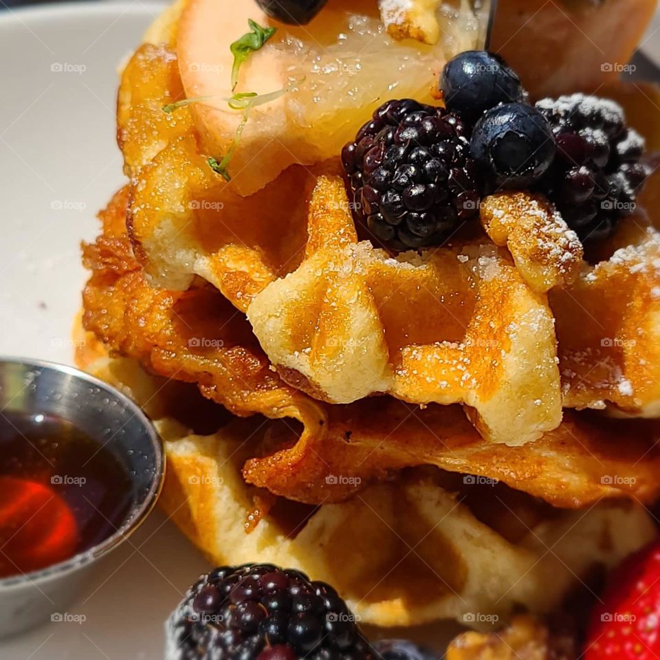 OMG the most amazing chicken and waffles ever, with fresh fruit, candied pecans, syrup, and succulent fried chicken. Strawberries, blueberries, and blackberries