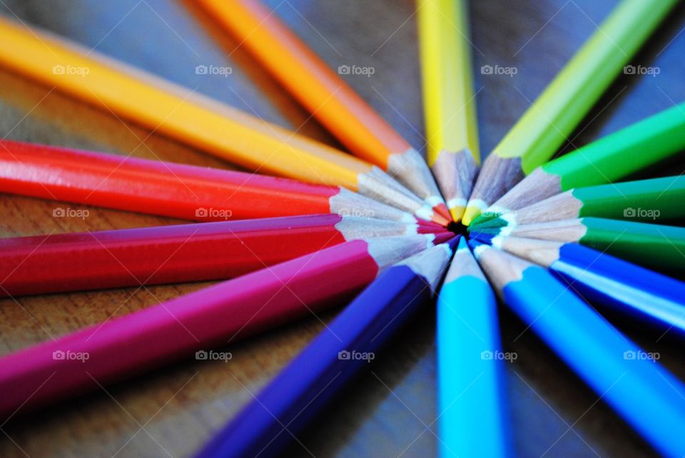 Arrangement of colorful pencils on wooden table