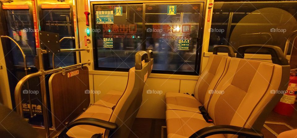 A retro-style bus with a warm yellow light interior.Safety equipment window breakers.bus seat