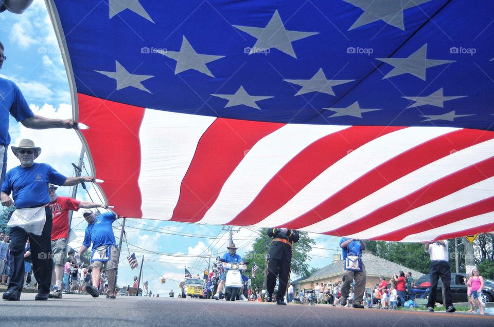 Low angle of flag as it goes overhead during parade