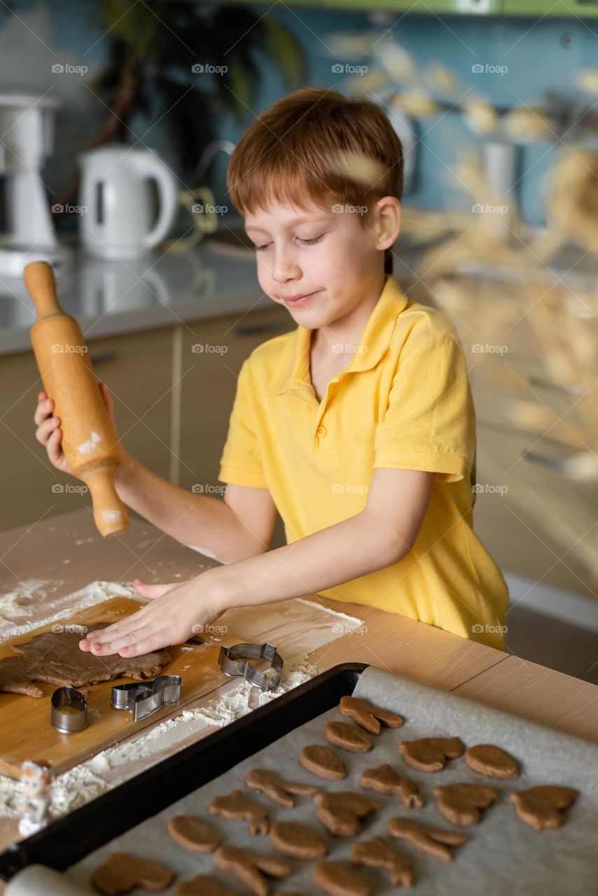 child boy redhead prepares cookies at home in the kitchen, fun