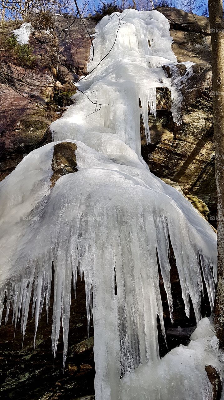 Frozen waterfall on the mountain melting in the spring - fruset vattenfall på berg som smälter i vårsolen 