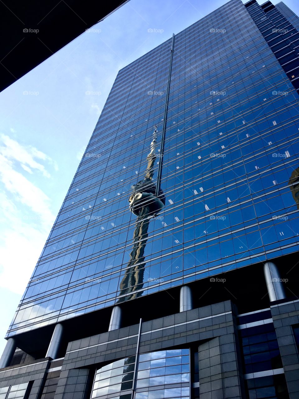 CN Tower reflecting in mirrored glass building 