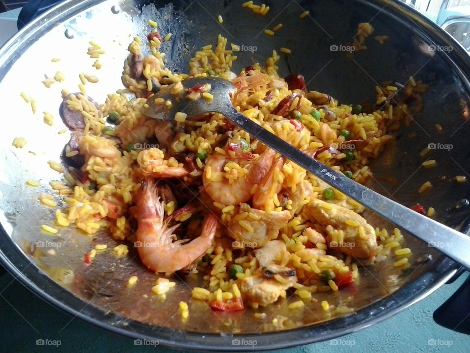 Delicious Spanish food speciality rice paella. Delicious speciality Paella composed of yellow saffron rice, seafood, chicken, chorizo and green peas