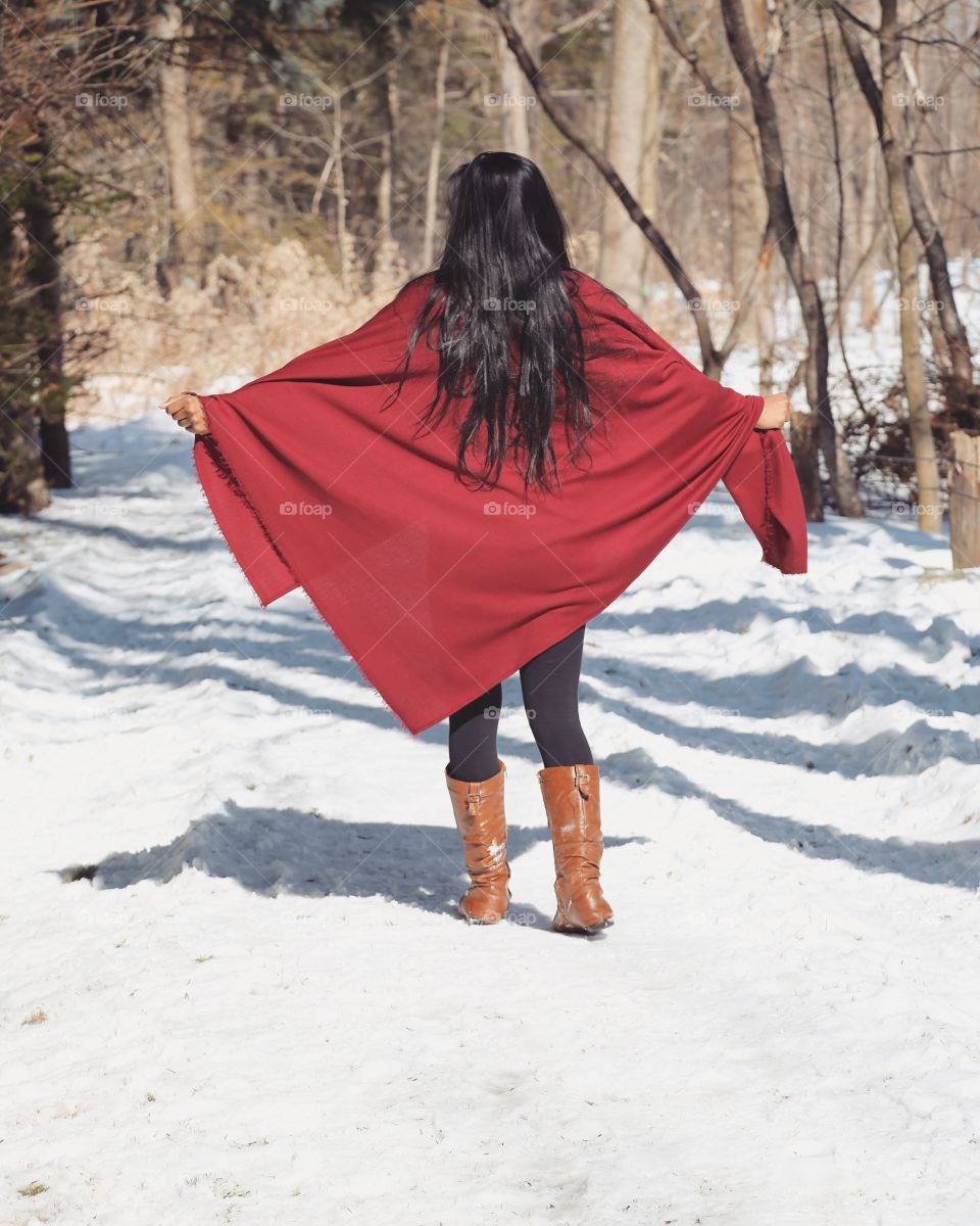 Red scarf held out by a young girl in the winter