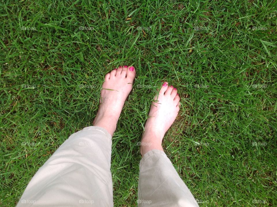 Feet in the green grass.