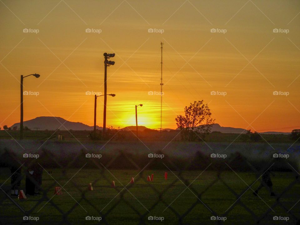 The sun sets behind the mountains lighting the sky with beautiful color.