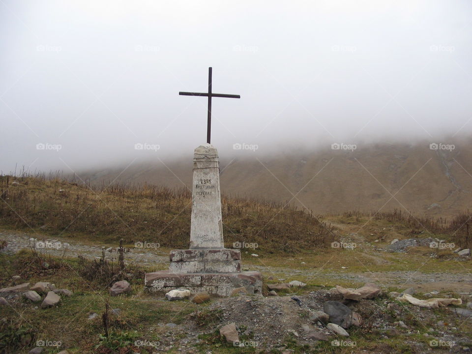 Jvari pass (cross pass) mark 2395 meters in Gudauri, Georgia on foggy Autumn day in high altitude at Caucasus mountains.