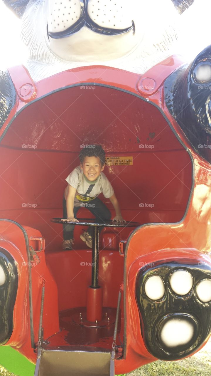 happy carnival ride. son having a blast at the fair