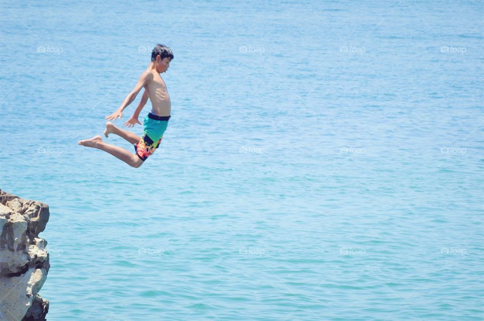 Boy jumping off the cliff