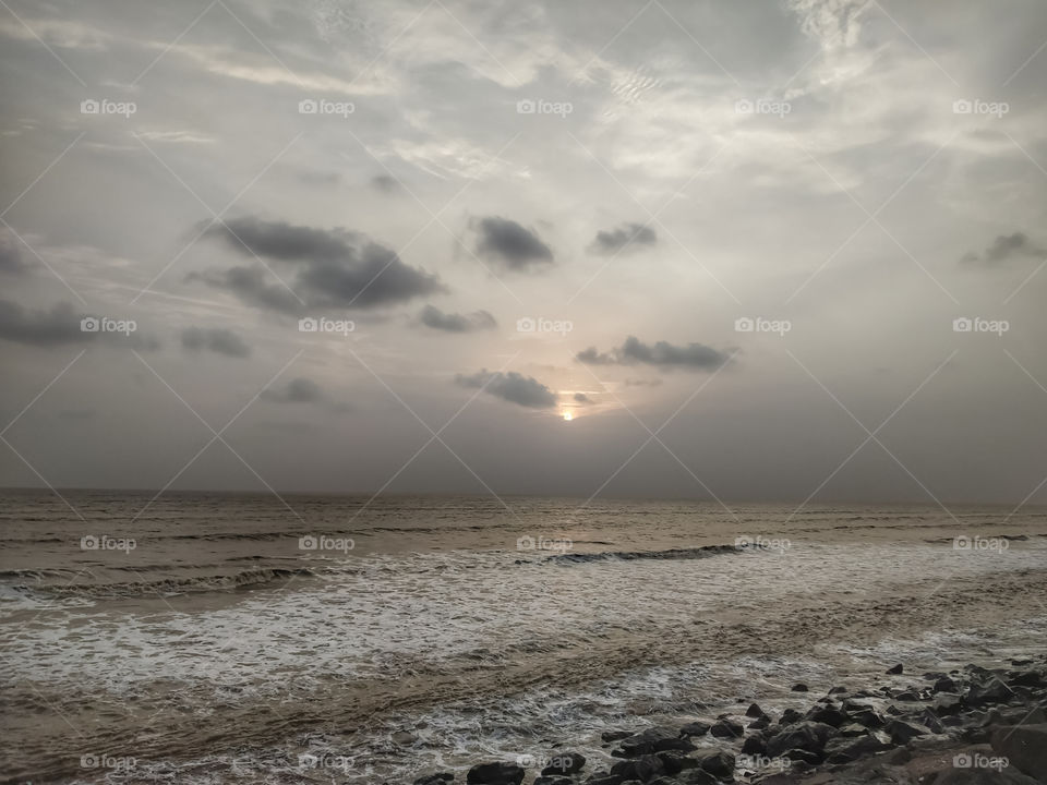 He watched the sunset at the horizon, spreading its largess into a grateful sky.