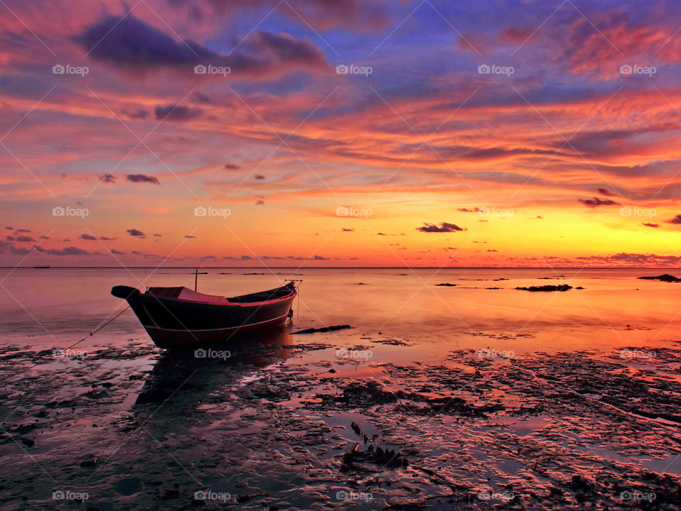 Alone boat under Sunset at Batakan beach, South Borneo, Indonesia.