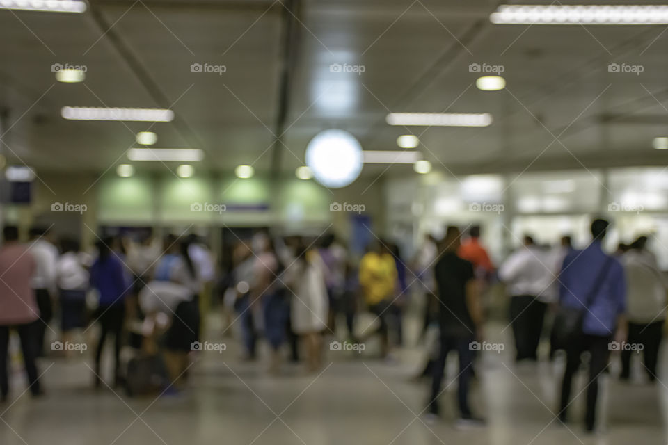 Blurry image of passengers stand waiting for the train.