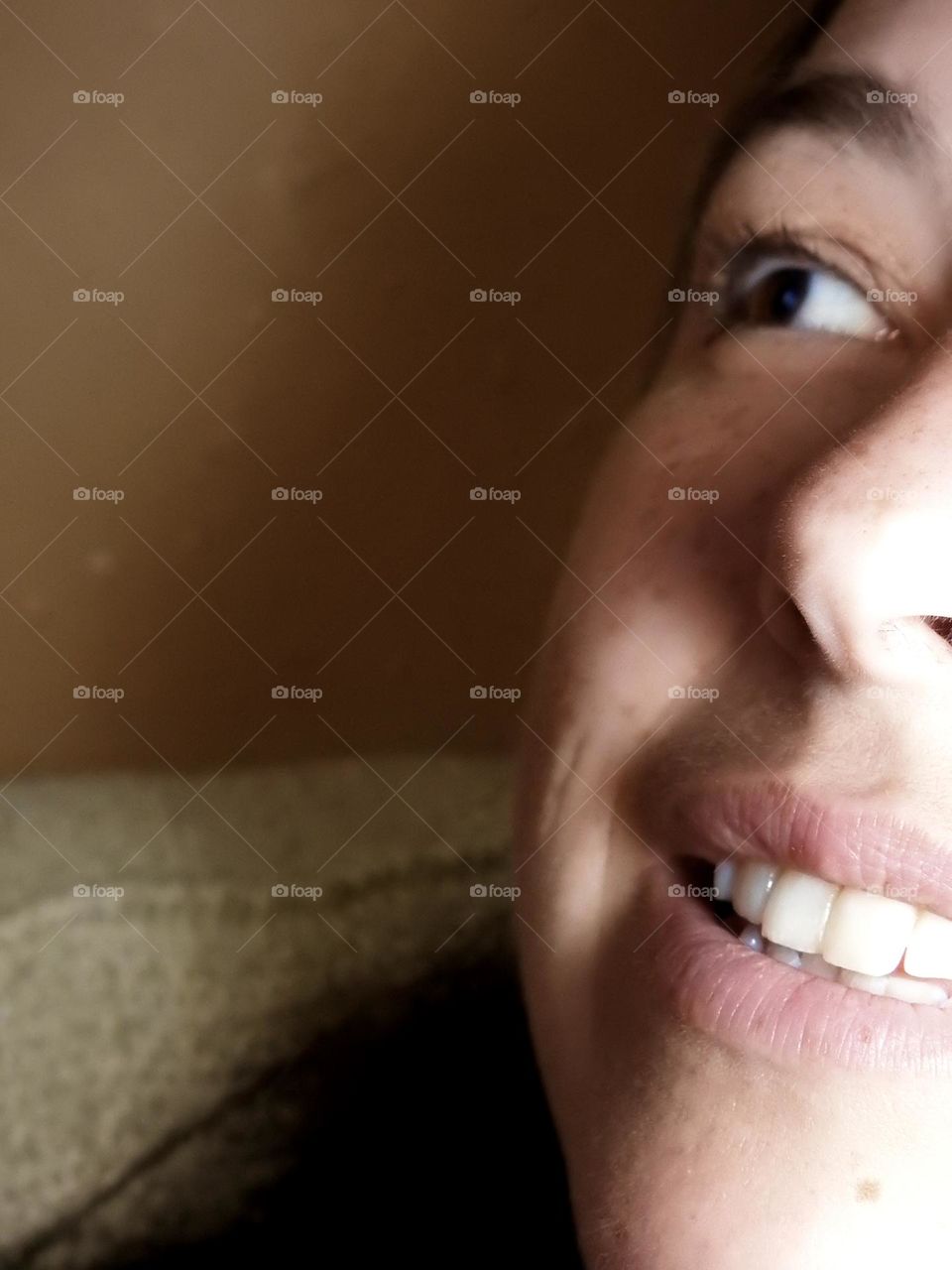 Face skin in the forties of a woman with freckles and brown hair close-up.