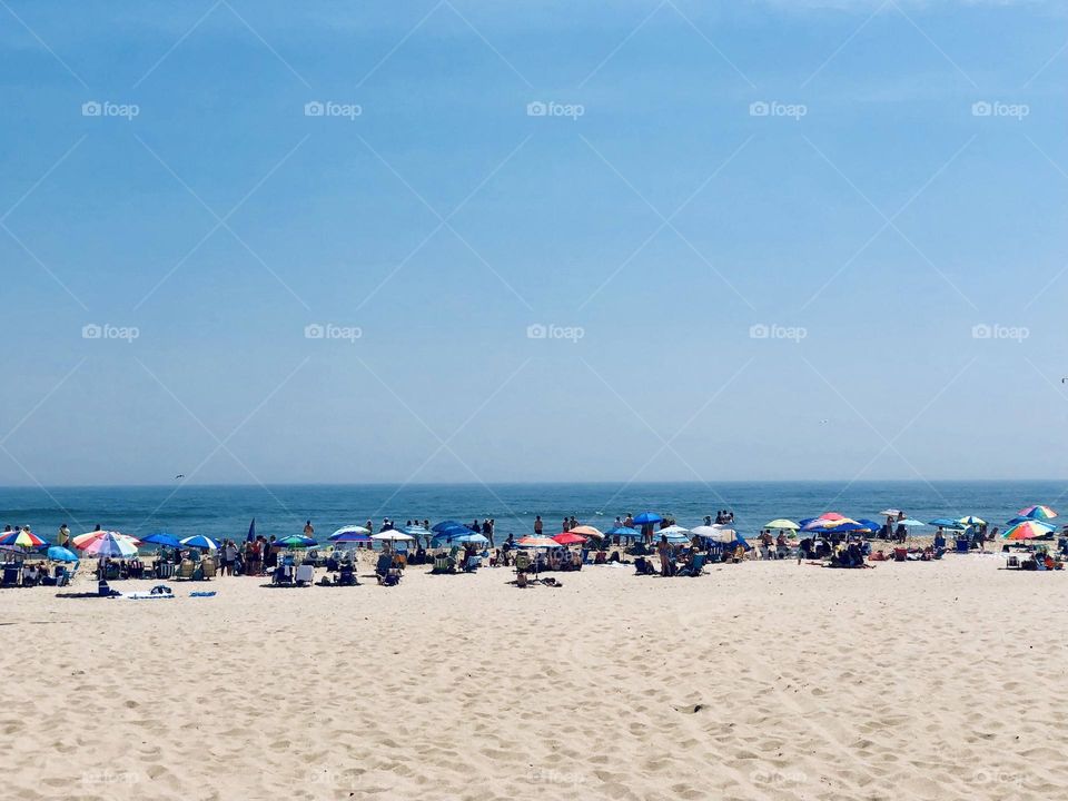 Beautiful day at the beach for sunbathing, people watching and fun. 