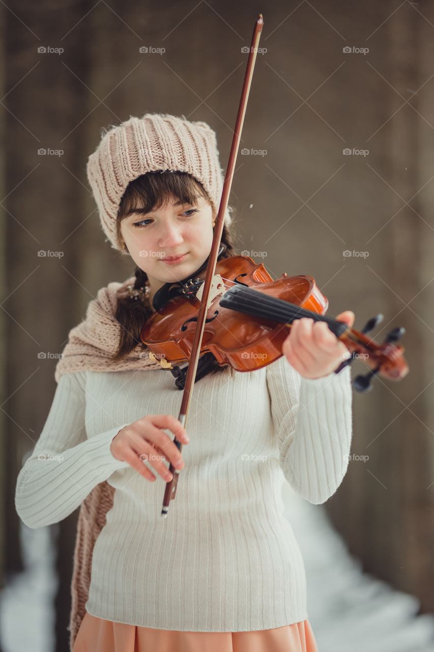 Teenage girl portrait with violin in winter park
