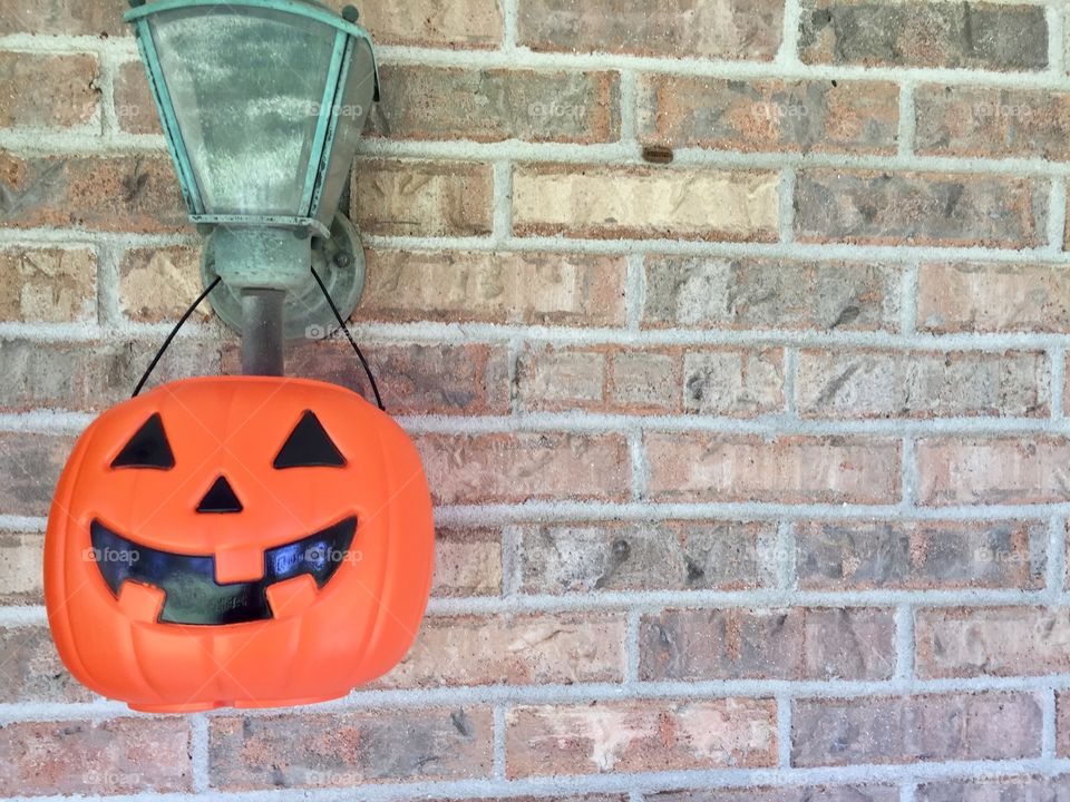 Plastic pumpkin  decoration on a brick wall