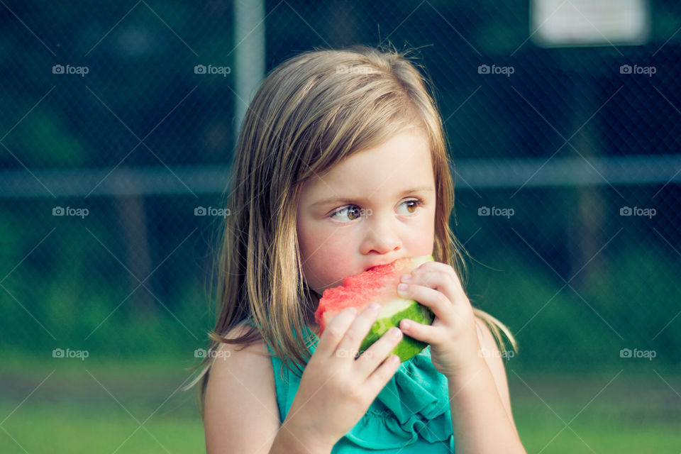 Young Girl Eating Watermelon Outside at Park 6