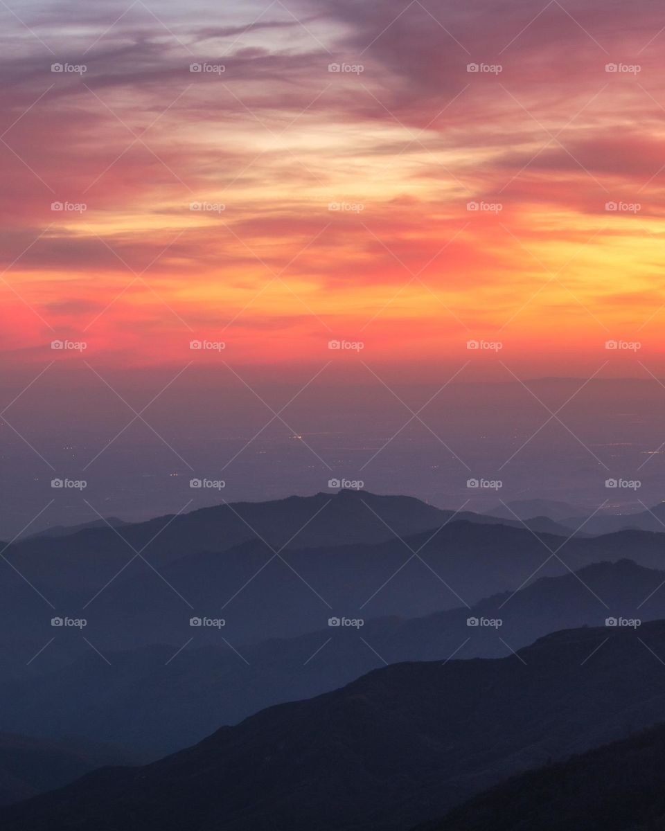 Gorgeous colorful sunset over layers of mountains fade into the distance