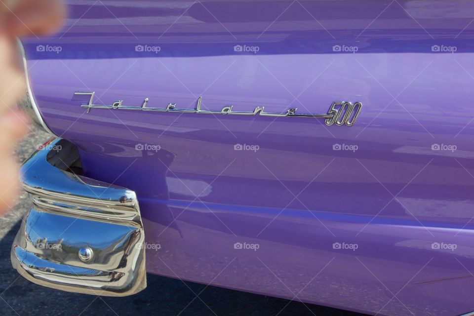 A side view of the rear fender and bumper of an auto  parked on the street in Havana, with the lettering Fairlane 500.