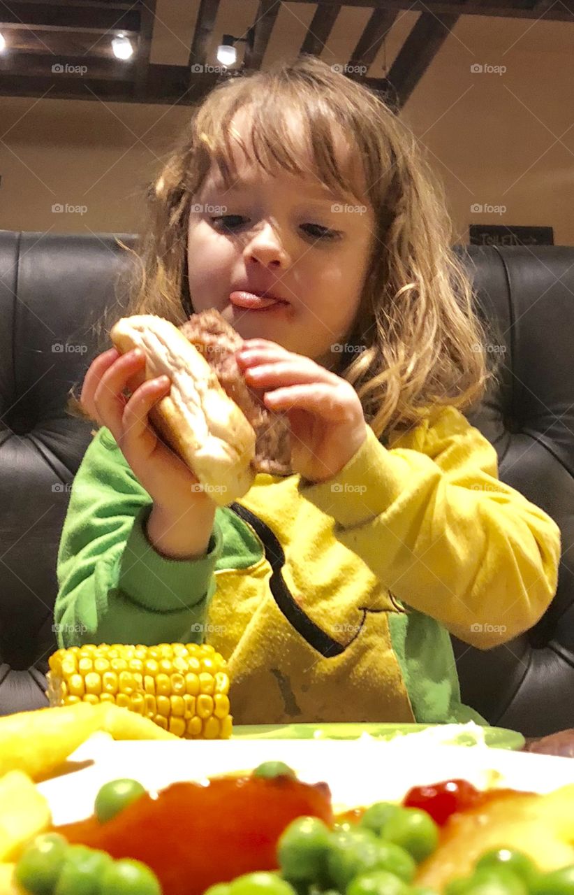Young girl eating hotdog 