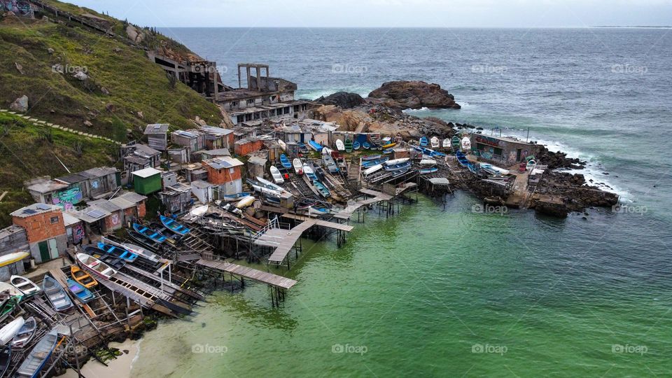 Fishing port and wharf in Arraial do Cabo. Construction of storage rooms and scaffolding to hold boats and fishing equipment perched on the cliff
