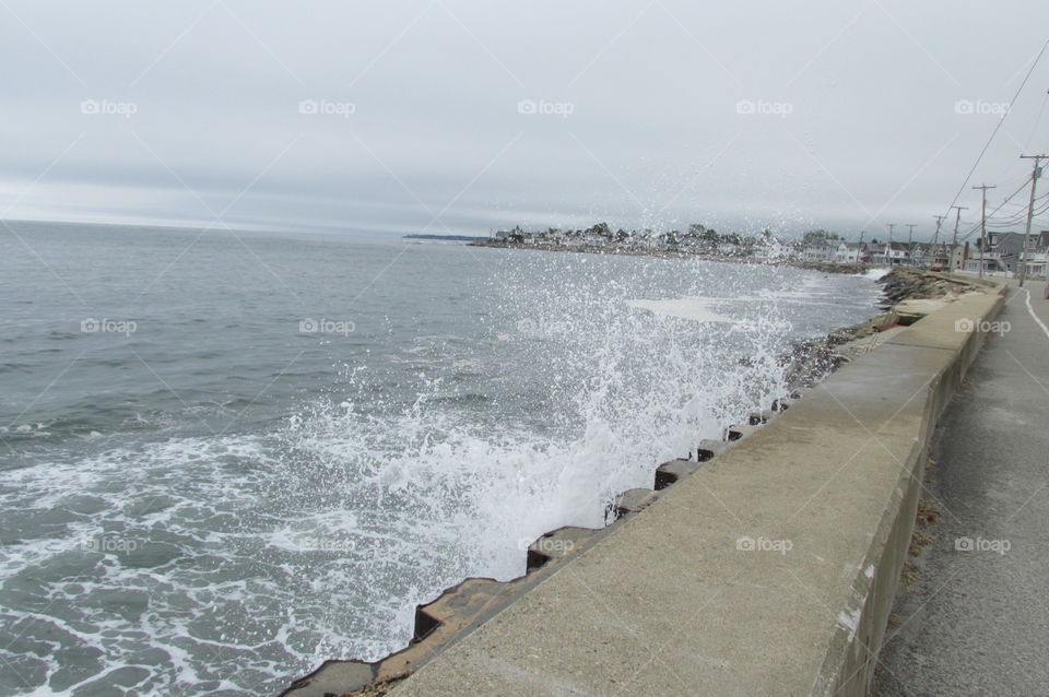 The Floodwall. The waves crashing against the floodwall near Wells Beach in Maine during high tide.
