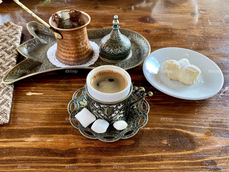 a cup of strong coffee in Turkish in your favorite oriental cafe. Cezve, cup of coffee, curabier cookies and a few pieces of homemade sugar