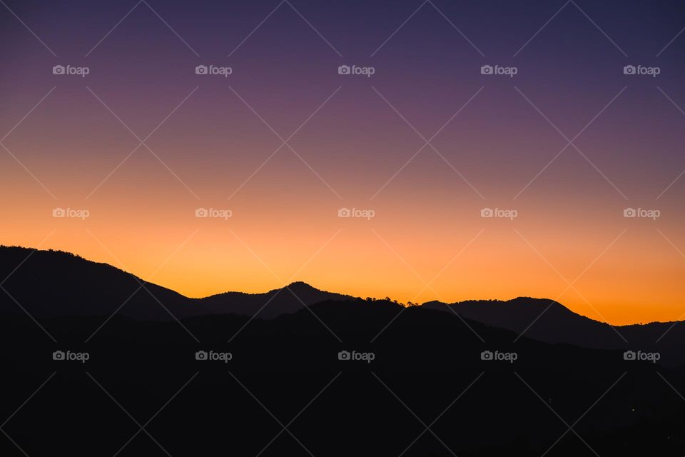 The vibrant colors of the sky during the dawn hour.