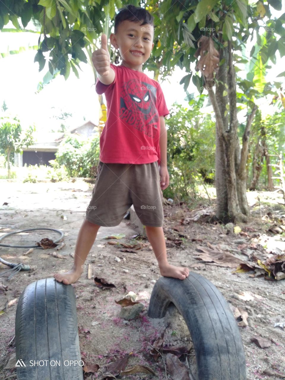 Boy Standing On Tyre