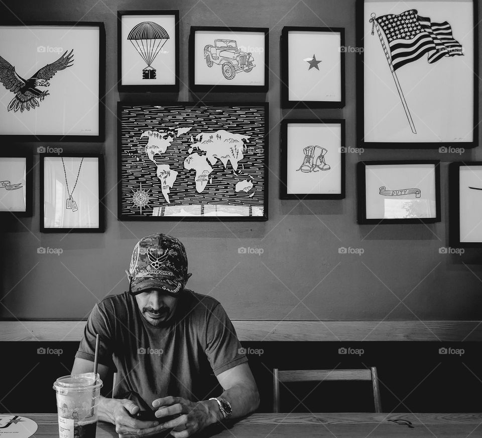 A cafe with a decorative collage wall honoring veterans in black and white.