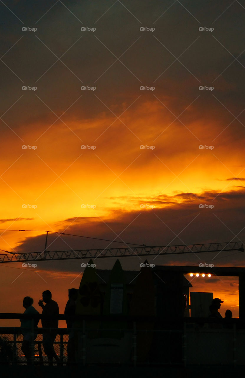 People strolling across the pier to catch a glimpse of this spectacular sunset over the Gulf of Mexico!