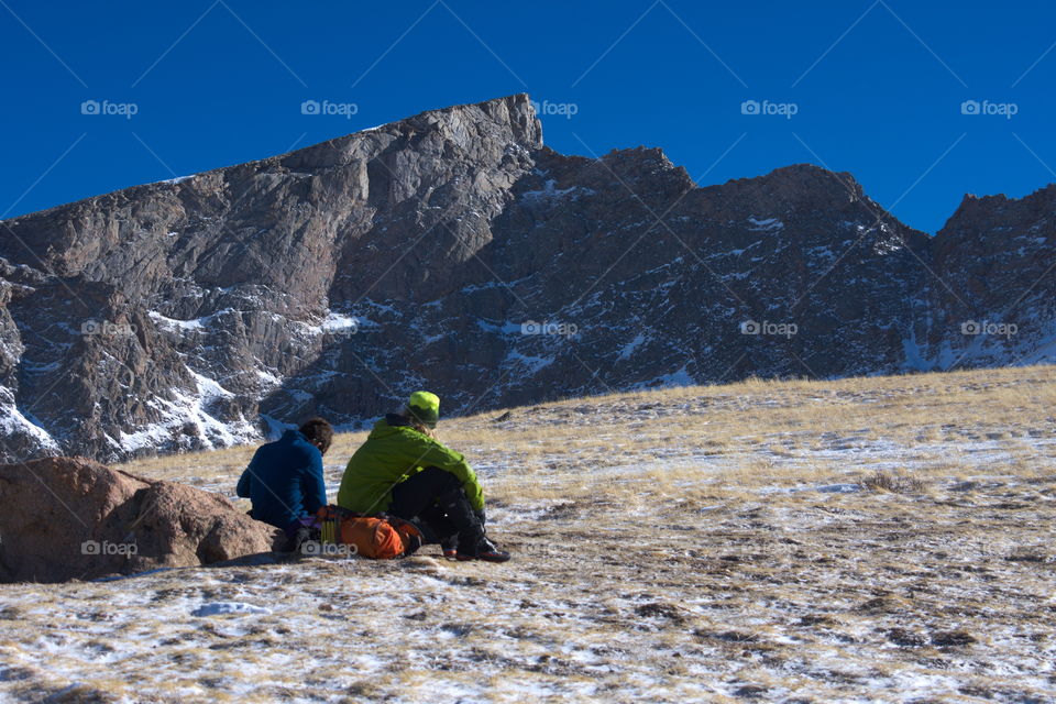 Two men rest during a mountaineering ascent.