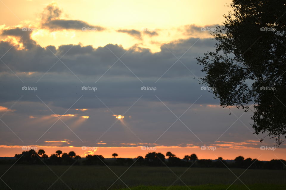 A cloudy sky at sunset with grey and purple clouds and orange sky