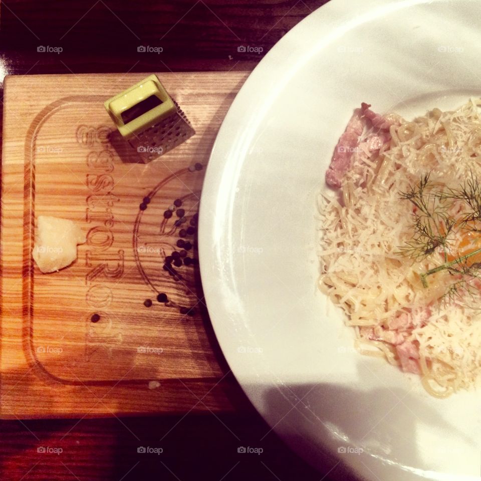 Delicious pasta Carbonara on a wooden tablet with cheese 