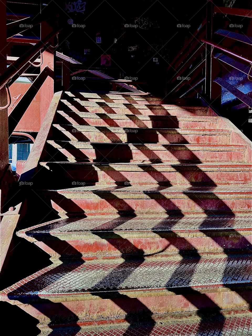 The light of the evening sun is painting pictures on the steps of the red metal staircase leading up to the “Pulaski Bridge” by casting shadows in a peculiar way that changes continuously over time. 2023. Hypnotic Productions