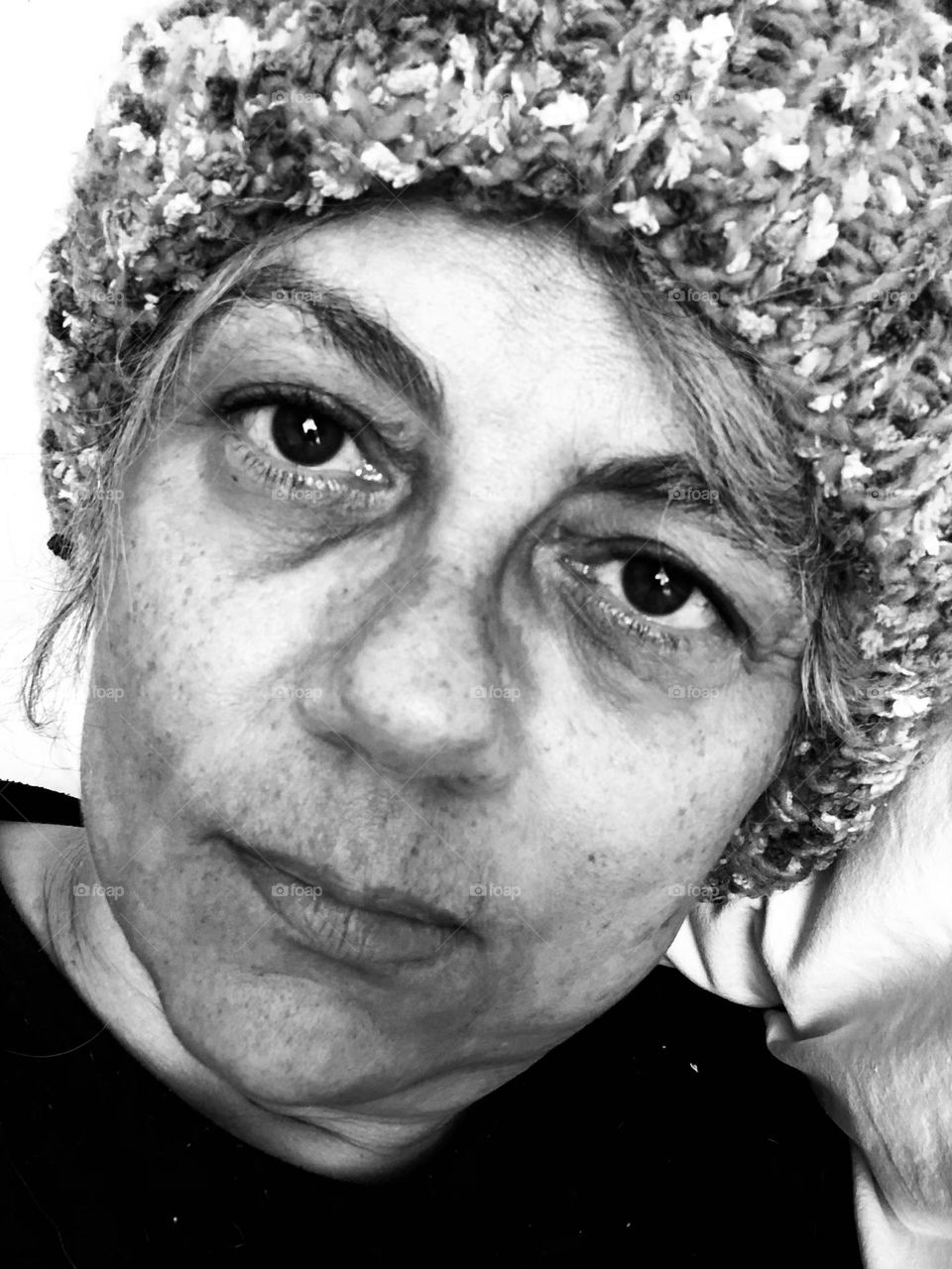 Woman in a wool hat shows her emotions for being stuck indoors during a particular cold winter weekend. 