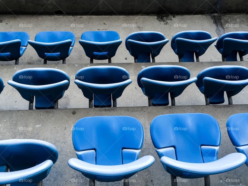 The blue color football stadium chairs background. 