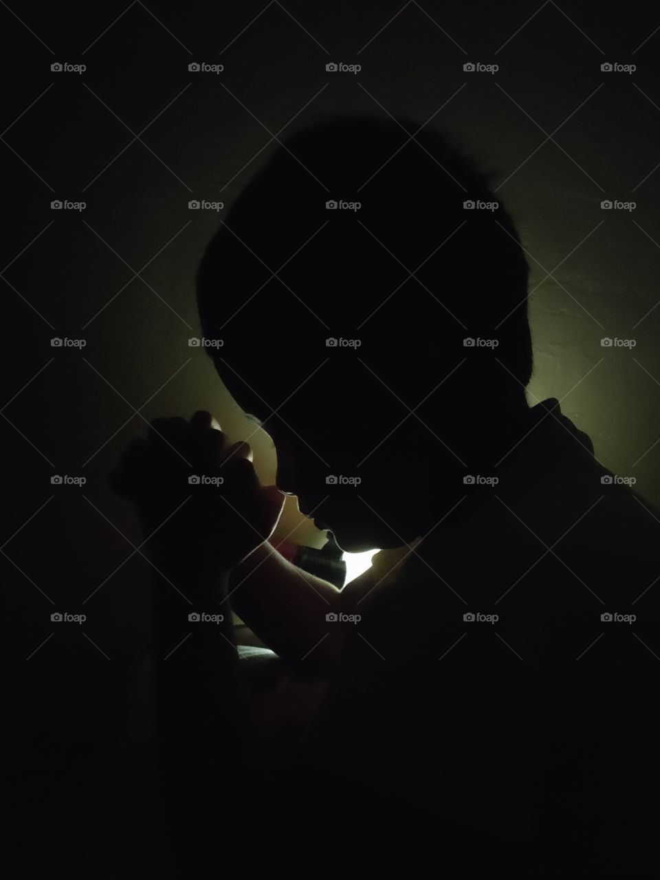 little kid praying in his shadow.