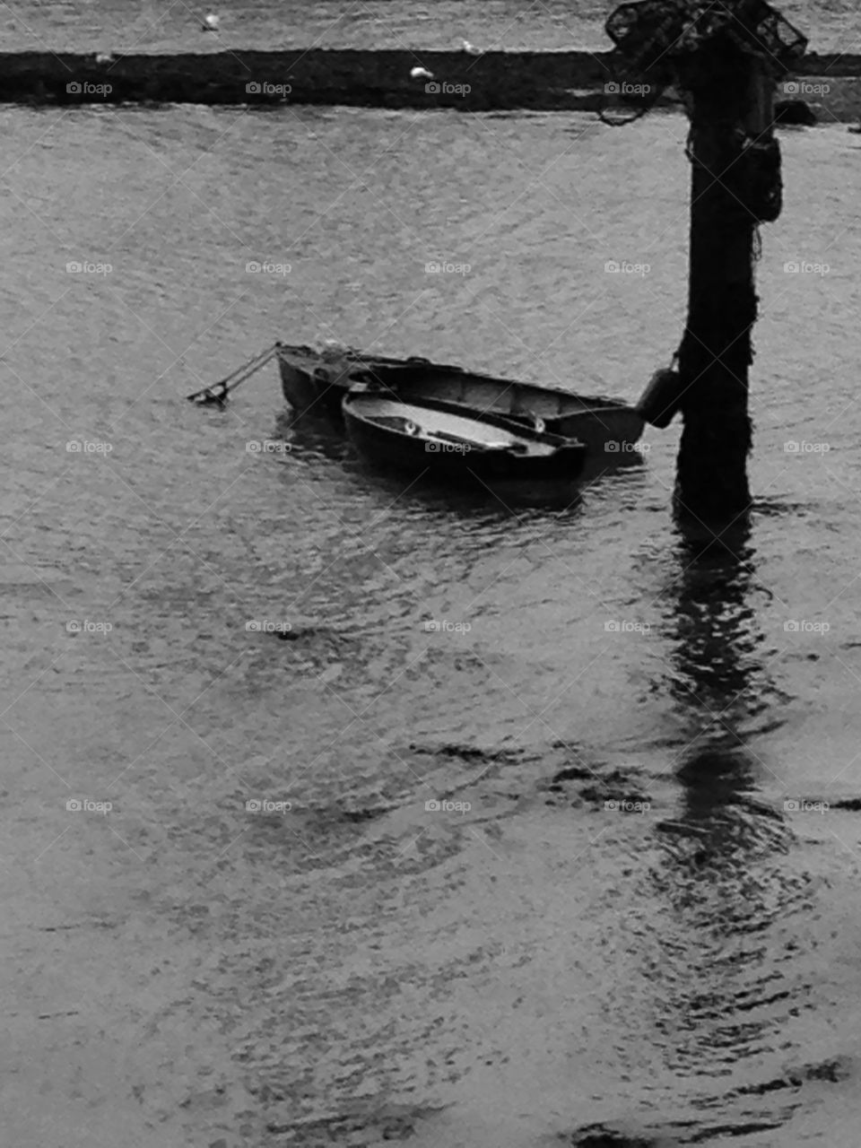 Row boat tied up to post 