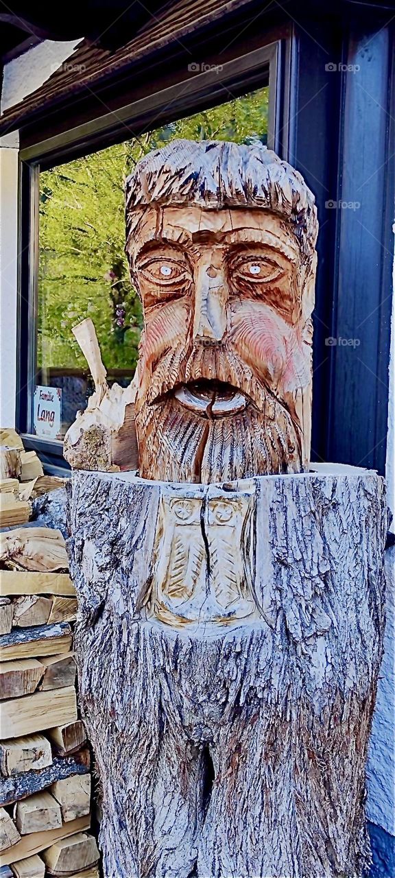 This oversized rather interesting looking wood sculpture seems to have been chiseled right from the tree trunk itself here in „Bayerischzell“, a small but very popular township near the Alps in „Bavaria“, Germany. 2024. Hypnotic Productions