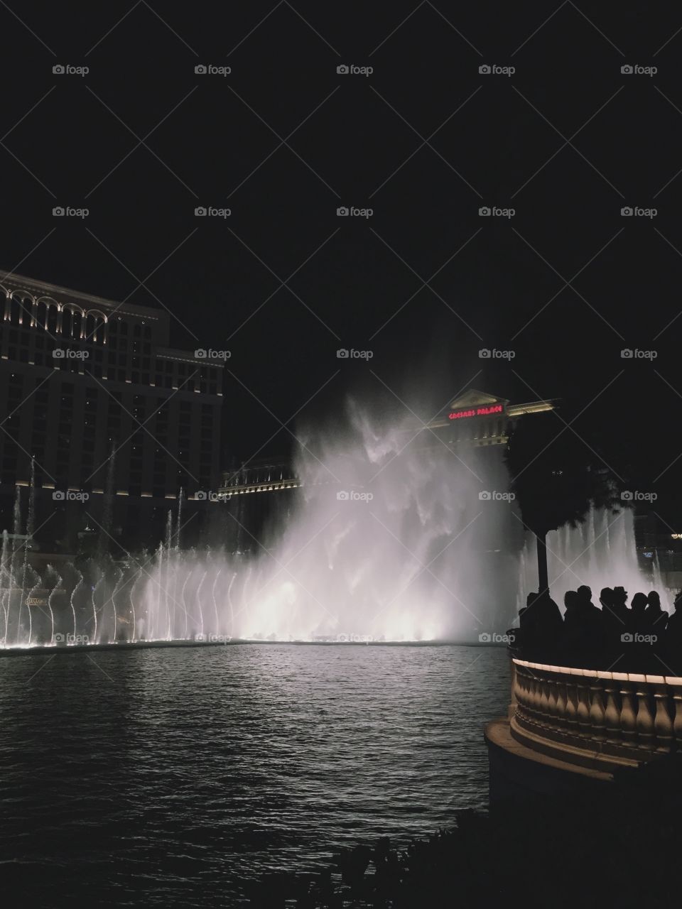 Bellagio fountain with silhouettes of people watching 