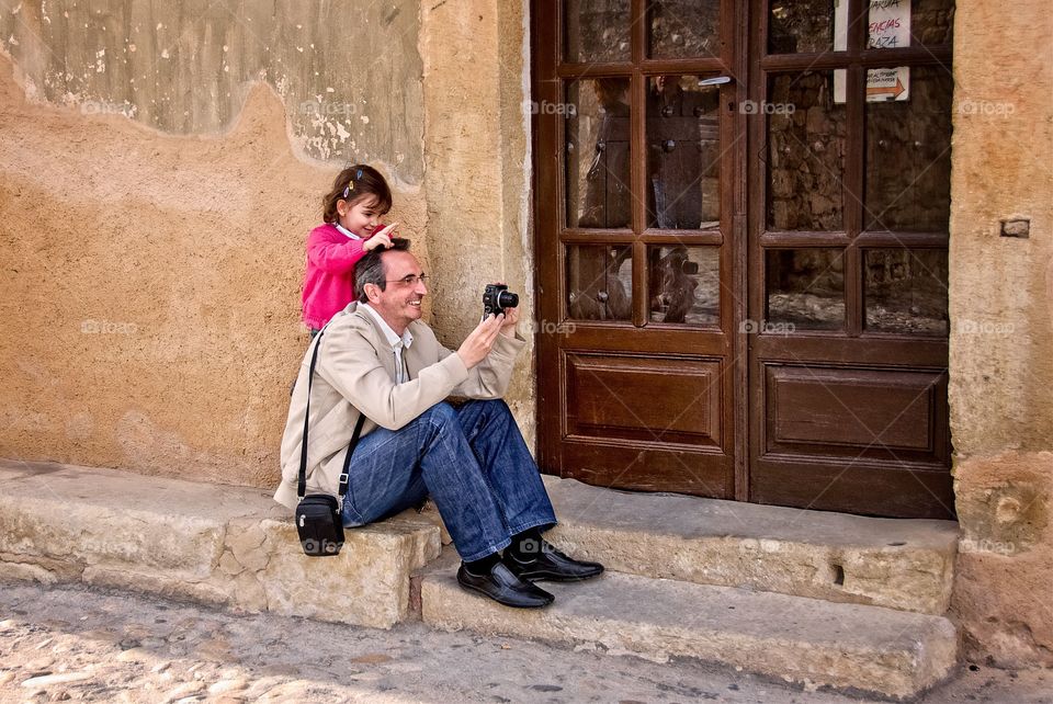 A  little girl with her father taking a photo