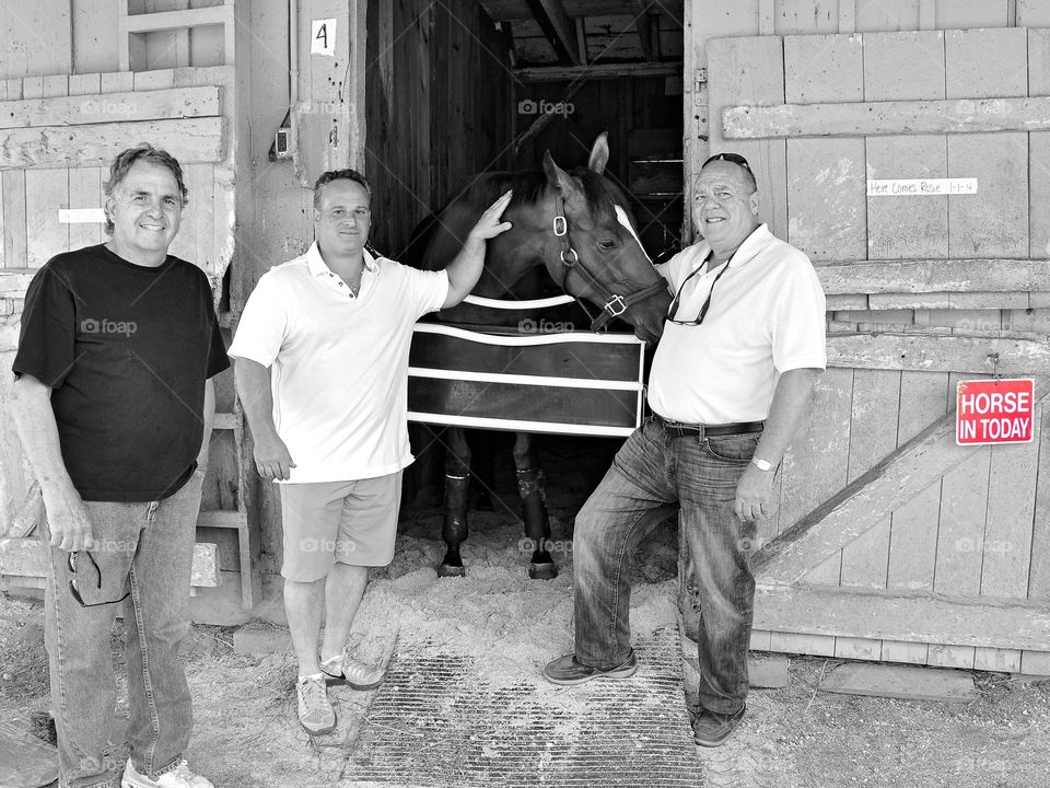 Horse Owners at the Barn. The owners of Here Comes Rosie posing with their bay filly at the barn in Saratoga.
Zazzle.com/Fleetphoto 