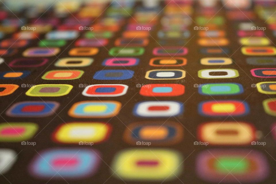 A colorful placemat with abstract pattern in perspective in brown background 